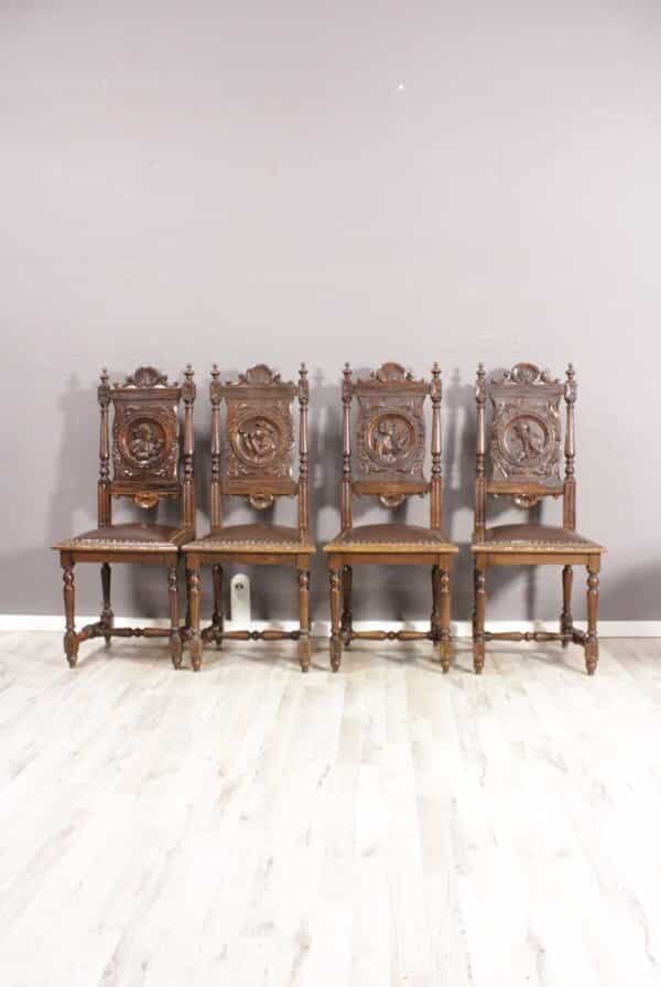4 einzigartige antike Gründerzeit Esszimmerstühle aus Eiche aufwendig mit bretonischen Figuren Schnitzereien verziert und neu mit Leder bezogen