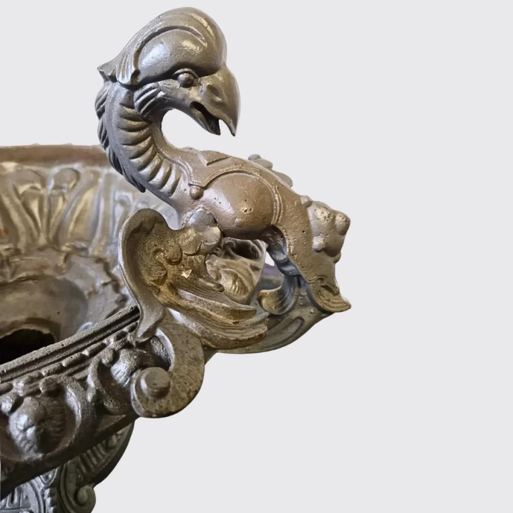 Detailaufnahme Drachenfigur antike JardinièreNahaufnahme der kunstvoll gearbeiteten Drachenfigur aus Gusseisen mit schöner Patina und feinen Details.