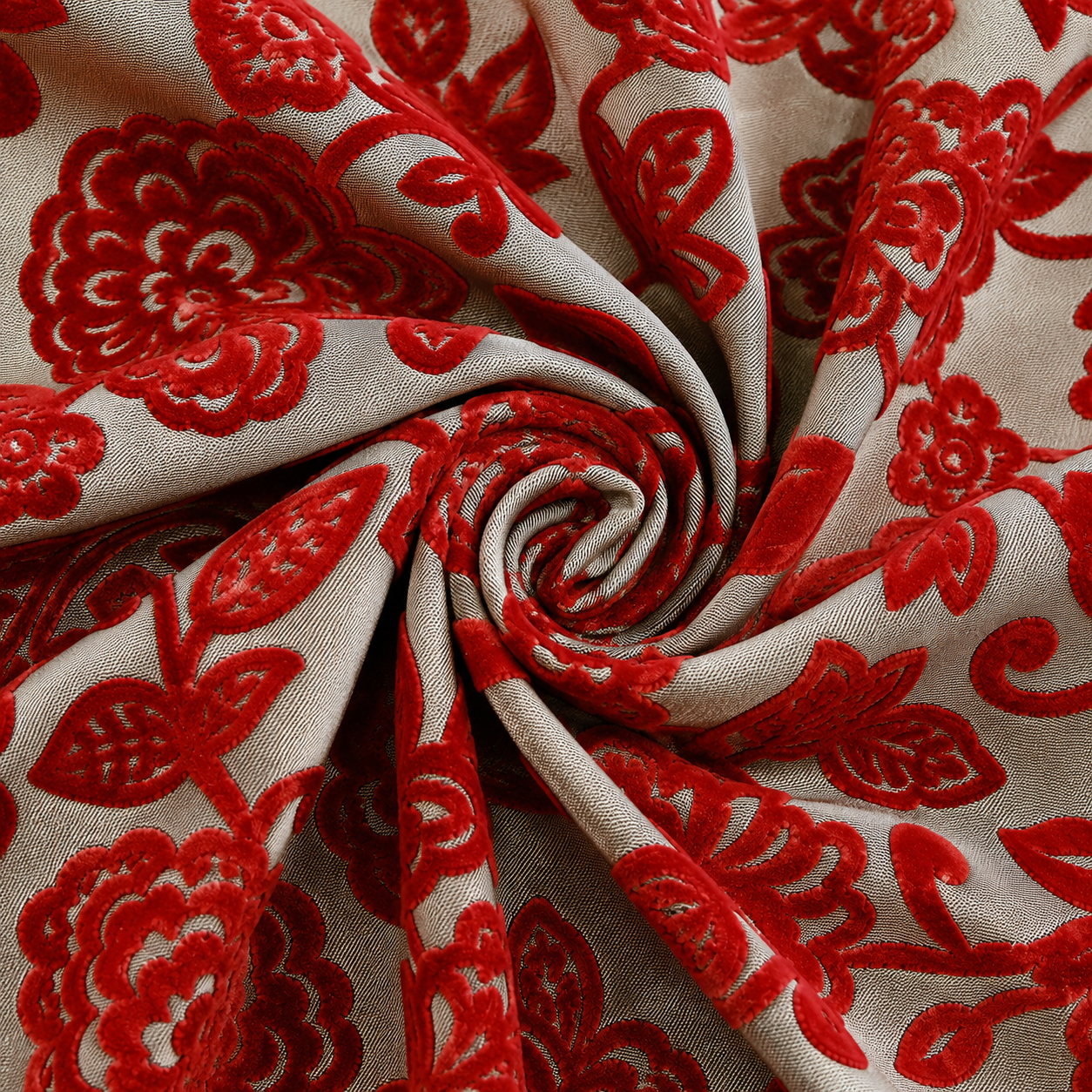 Veloursstoff mit rotem Blumenmuster dekorativ zur Spirale gelegt