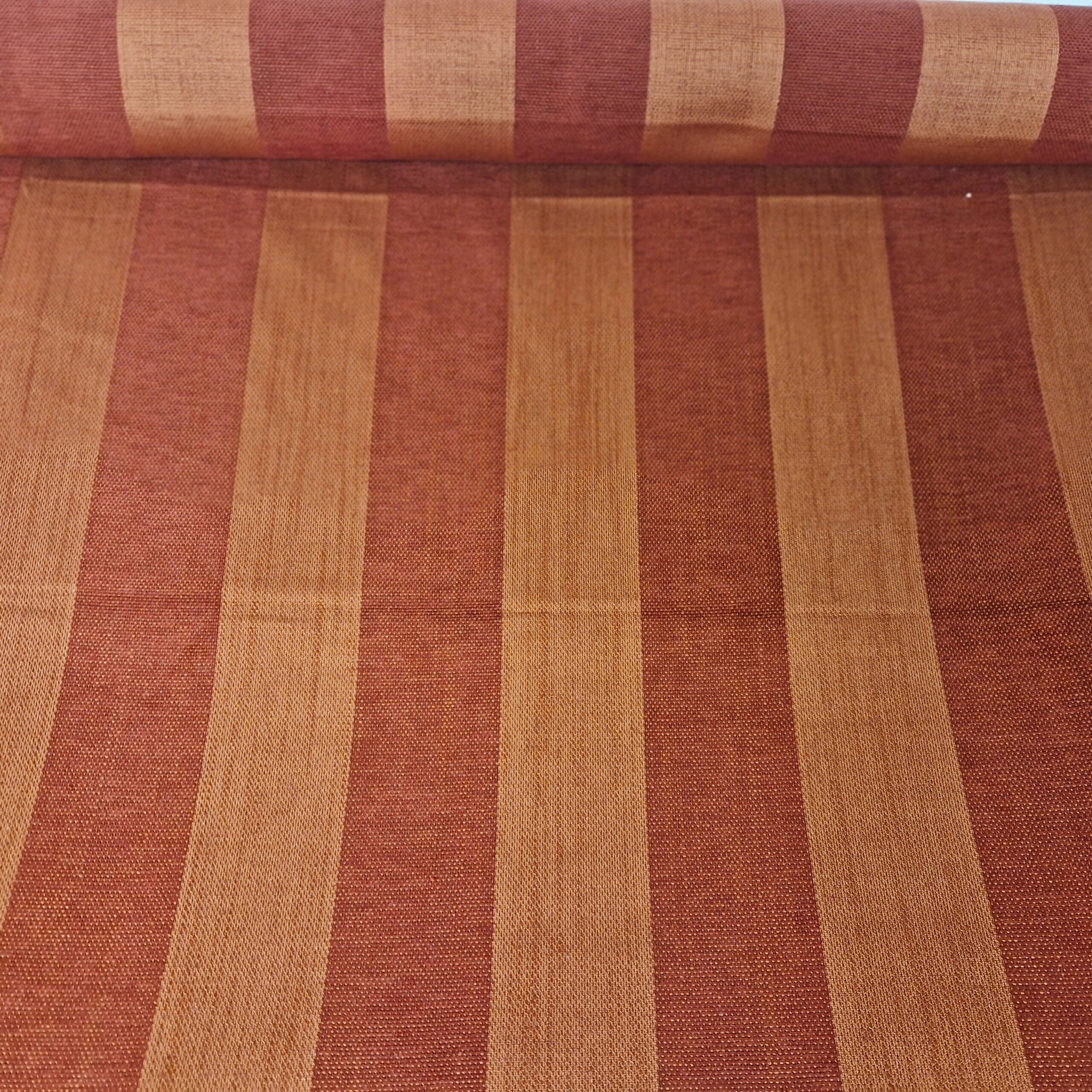 Makroaufnahme eines Chenille Möbelstoffes mit rot-terrakottafarbenen Streifen.