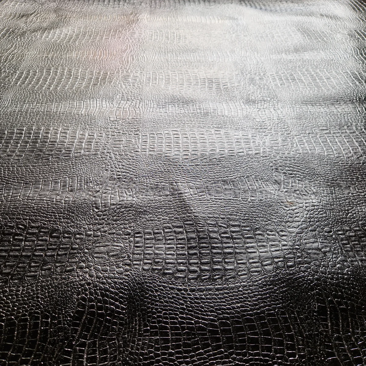 Schwarzes Kunstleder mit geprägtem Reptilienmuster